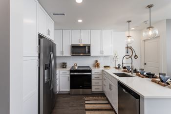 Contemporary kitchen with white cabinets and stainless appliances
